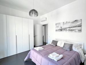 a bedroom with a purple bed with two towels on it at Luxury Apartment in Crotone