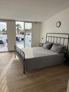 a bedroom with a large bed and a balcony at Villa Palma Cabo Roig 31a in Orihuela Costa +25 photos