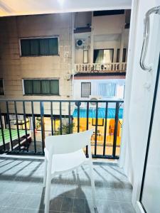 a white chair on the balcony of a building at Patong Beach Verve in Patong Beach