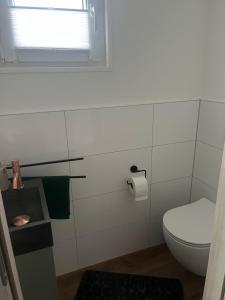 een witte badkamer met een toilet en een raam bij Hausboot - Nordsonne 10 in Wangerland +6 foto's