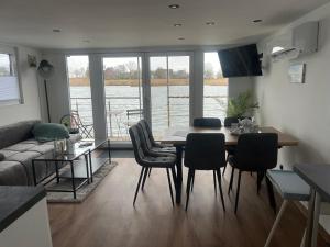 een woonkamer met een tafel, stoelen en een bank bij Hausboot - Nordsonne 10 in Wangerland