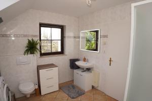 ein Badezimmer mit Waschbecken und Toilette und einem Fenster in der Unterkunft Panoramablick, ruhiger Lage, 20 Min nach Köln - EVARIS Hilda in Overath