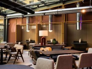 een kamer met tafels en stoelen en een lamp bij You Hotel Budapest - Handwritten Collection in Boedapest