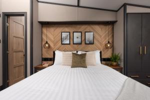 een slaapkamer met een groot bed met witte kussens bij Clumber Park Lodges in Worksop