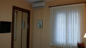a room with a white curtain and a window at Hostal Angelines in Madrid