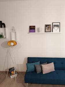 ein blaues Sofa im Wohnzimmer mit einer weißen Wand in der Unterkunft Civico 16 in Perugia