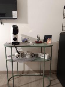 ein Glasregal mit einem Tisch, auf dem Geschirr und ein Mixer stehen in der Unterkunft Civico 16 in Perugia