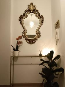 ein Spiegel an einer Wand über einem Tisch mit einer Pflanze in der Unterkunft Civico 16 in Perugia