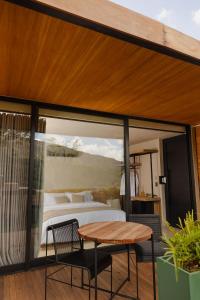 a bedroom with a bed and a table on a balcony at Bowi Hotel Conceito in Tiradentes