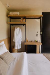 a bedroom with a white bed and a sink at Bowi Hotel Conceito in Tiradentes