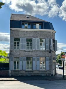 ein Backsteingebäude mit weißen Türen und Fenstern in der Unterkunft Spacieux studio rénové en centre ville - Apt7 in Givet