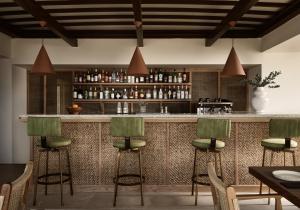 a bar with green bar stools in a restaurant at Gerakas Belvedere Hotel & Spa in Vasilikos