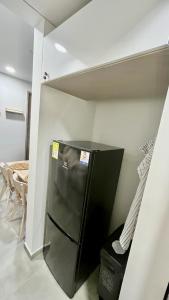 - une cuisine avec un réfrigérateur noir dans la chambre dans l'établissement Samaia Loft, à Santa Marta