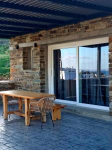 ein Holztisch und Stühle vor einem Fenster in der Unterkunft Sea melody tinos 3 in Agios Sostis