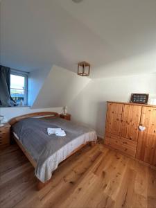 a bedroom with a bed and a wooden dresser at Sonnenhus 1 - BreegeRügen in Breege