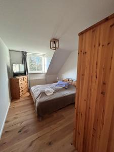 a bedroom with a bed and a large wooden closet at Sonnenhus 1 - BreegeRügen in Breege