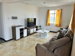 un salon avec un canapé et une télévision dans l'établissement Coconut House, à Albion