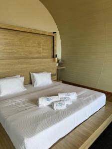 a large white bed with three towels on it at Glenmour Resort Ella in Ella +41 photos