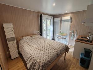 een kleine slaapkamer met een bed en een raam bij Studnature in Dunes