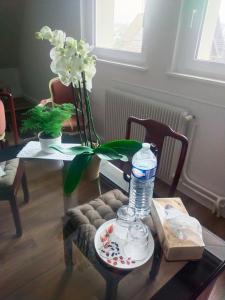 a table with a bottle of water and flowers on it at Les vignobles d'Alsace in Wintzenheim