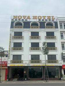een wit gebouw met een bord erop bij Nova Hotel 1 Phú Thọ in Chú Mật