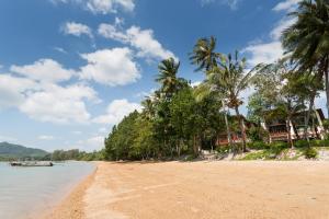 a beach with palm trees and houses on it at Amatapura Beachfront Villa 12, SHA Certified in Ao Nam Mao