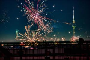 a fireworks display with the tv tower in the background at Hotel Indigo Berlin - East Side Gallery in Berlin