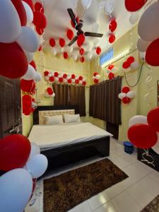 a room with a bed with red and white balloons at Kashiyana in Varanasi