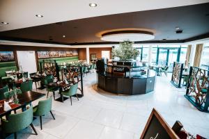 een eetkamer met tafels en stoelen en ramen bij Farmer Hotel Basedow & Spa in Basedow