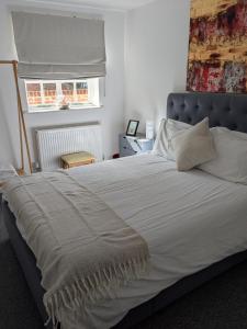 a bedroom with a large white bed with a window at St Davids House in Cranbrook