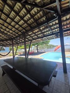 een pingpongtafel in een paviljoen met een zwembad bij Refúgio Testoni in São Francisco do Sul +15 foto's