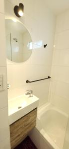 a bathroom with a sink and a tub and a mirror at EmBruHadas Violet in San Salvador de Jujuy