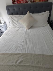 a white bed with white sheets and pillows at St Davids House in Cranbrook