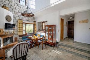 a living room with a table and a brick wall at Stone Villa Monolia in Amaliapoli