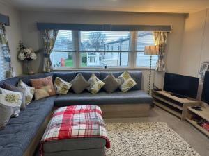 a living room with a blue couch with pillows at Horizon Bay in Longniddry