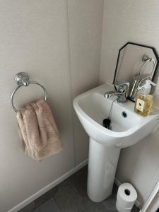 a bathroom with a sink with a mirror and a towel at Horizon Bay in Longniddry +34 photos
