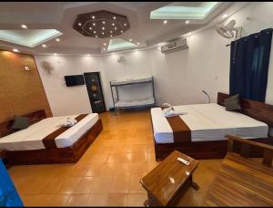 een kamer met 2 bedden en een tv. bij BanyanTree Aayur in Trivandrum