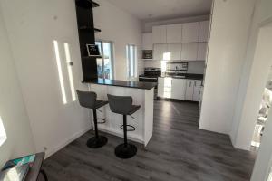 een keuken met een aanrecht en 2 krukken bij Luxury Apt with Amazing Views in Saint Johnʼs +4 foto's