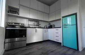 een keuken met witte kasten en een blauwe koelkast bij Luxury Apt with Amazing Views in Saint Johnʼs