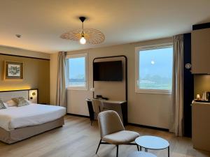 a hotel room with a bed and a desk and chair at Brit Hotel Saint-Méen-le-Grand en Brocéliande in Saint-Onen-la-Chapelle +70 photos