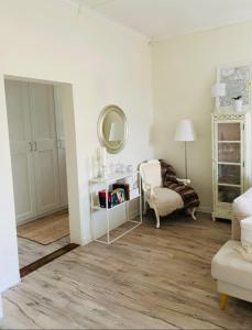 een witte woonkamer met een spiegel en een stoel bij Helsingebockens Fastigheter 