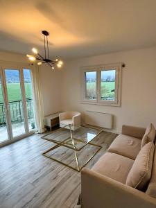 een woonkamer met een bank en een aantal ramen bij Maison partagée Bonneville in Bonneville