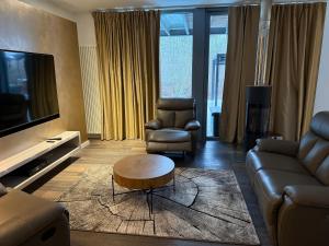 a living room with a couch and chairs and a tv at Wellness Oase in Paderborn