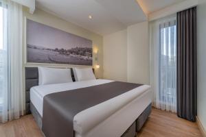 a large white bed in a room with windows at Rai Premium İstanbul in Istanbul +22 photos