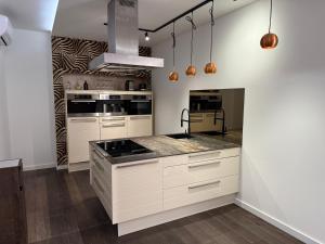 a kitchen with white cabinets and stainless steel appliances at Wellness Oase in Paderborn