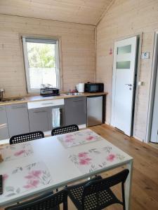een keuken met een tafel en stoelen in een kamer bij Domek letniskowy Borne Sulinowo in Borne Sulinowo