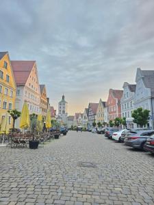 a cobblestone street in a town with cars parked at Ferienwohnung TALISA in Günzburg