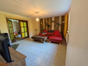 un soggiorno con un divano rosso e una TV di Fewo Kerzenzimmer - Märchen aus Wachs und Flamme a Garvensdorf