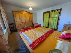 una camera da letto con un grande letto giallo e un armadio di legno di Fewo Kerzenzimmer - Märchen aus Wachs und Flamme a Garvensdorf