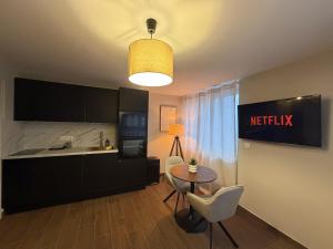 una cucina e un tavolo con sedie in camera di L'Hakuna II - Suite et Spa a Fontaine-Notre-Dame